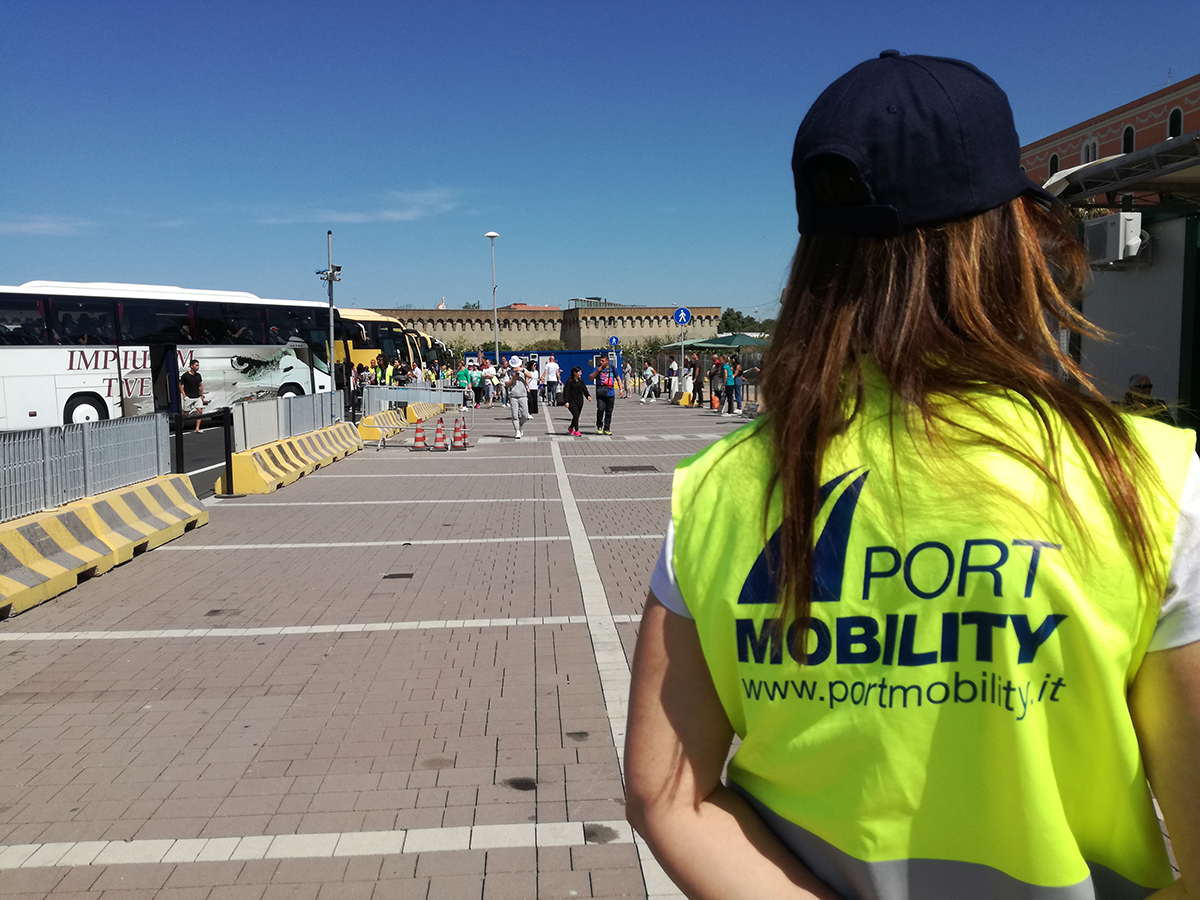 Ragazza dell'Infopoint presente a Largo della Pace. Sullo sfondo i croceristi